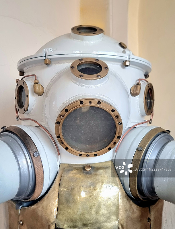 复杂的黄铜和玻璃潜水头盔，展示了20世纪初复古深海探险装备的工程奇迹和水下技术的演变图片素材