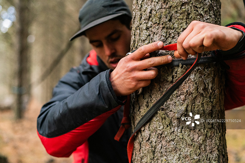 户外将松弛绳固定在树上的特写镜头。图片素材