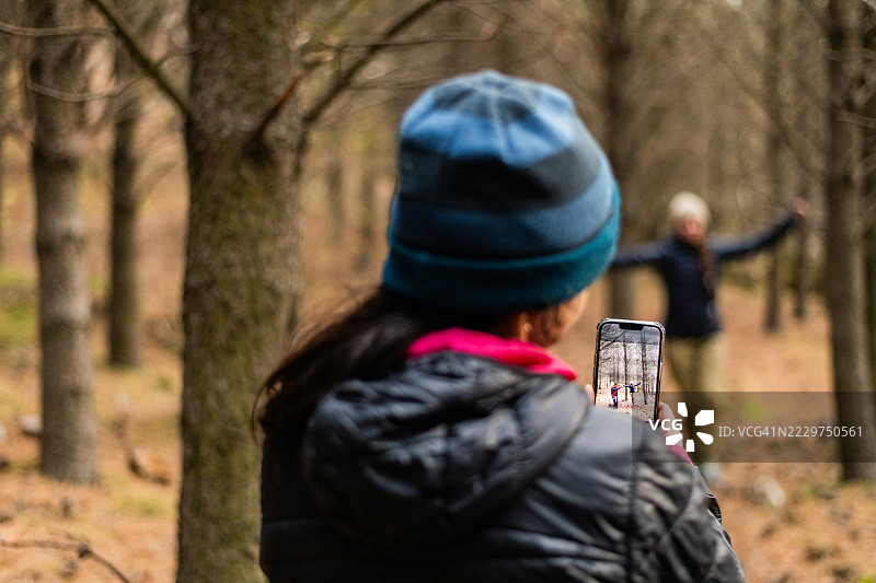 设备屏幕上显示一名女性在户外练习走绳的照片或视频图片素材