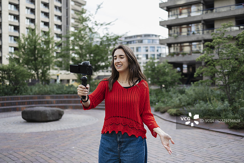 女性在城市环境中使用稳定器进行视频博客拍摄图片素材