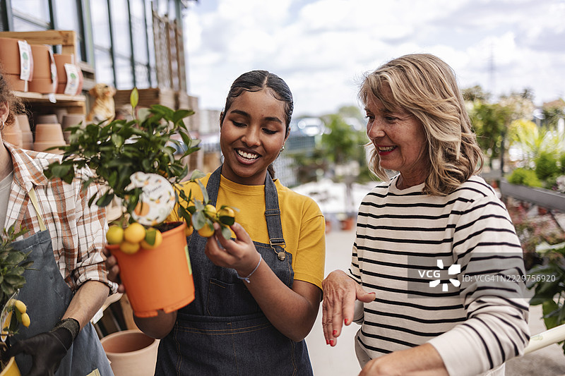 花店工作人员协助顾客选择植物图片素材
