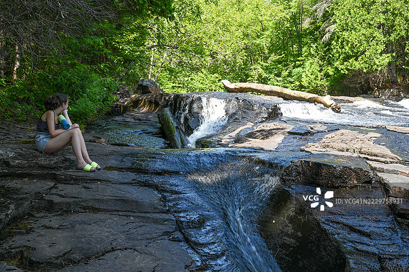 女孩青少年凝视着流淌的河水图片素材