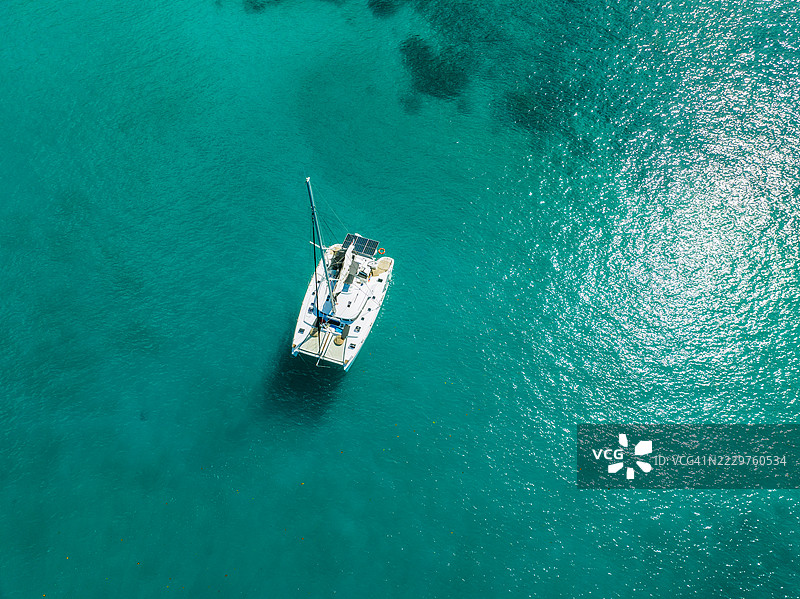 从上方俯瞰在塞舌尔附近的碧绿色海水中的帆船图片素材