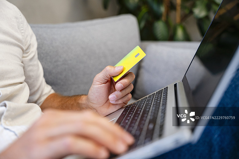 自信的人在家中使用信用卡和笔记本电脑进行在线支付图片素材