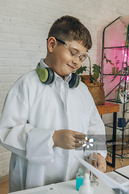 穿着实验室外套的学生在教室里使用移液管进行生物实验图片素材