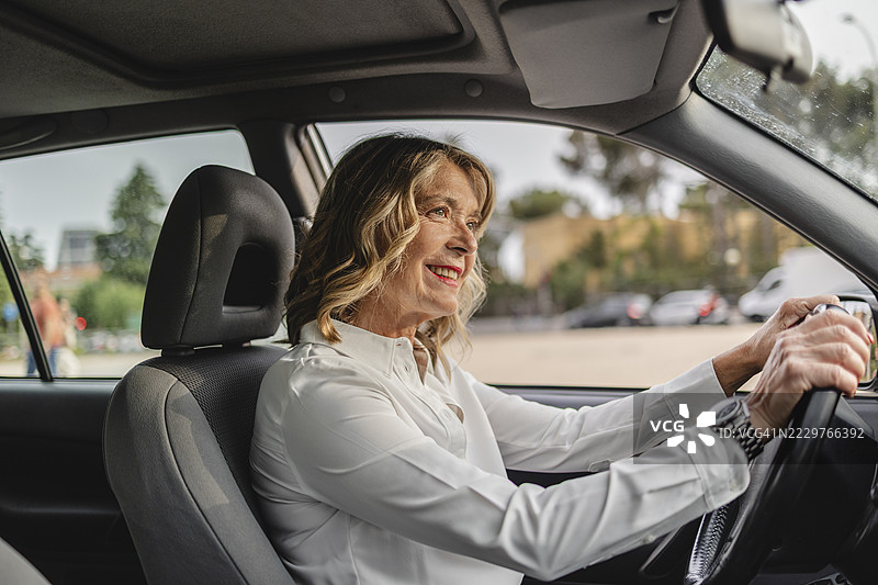 微笑的人在白天的城市里开车图片素材