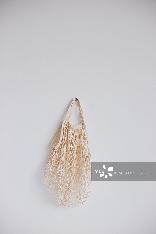 白墙上挂着的米色网袋的极简主义图像图片素材