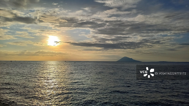 印度尼西亚海洋上的日落与远处的岛屿图片素材