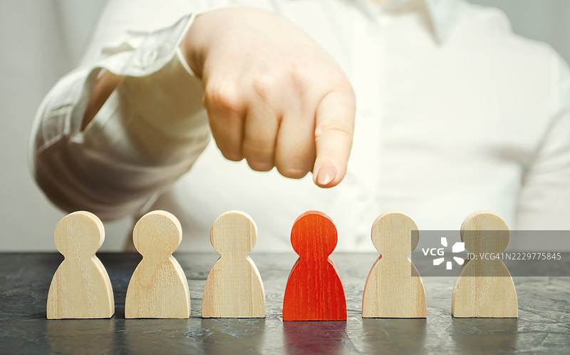 手指指向一个红色木制人形，象征着选择与淘汰，乌克兰图片素材