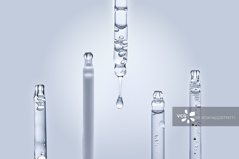 在浅色背景下释放液滴的面部精华滴管图片素材