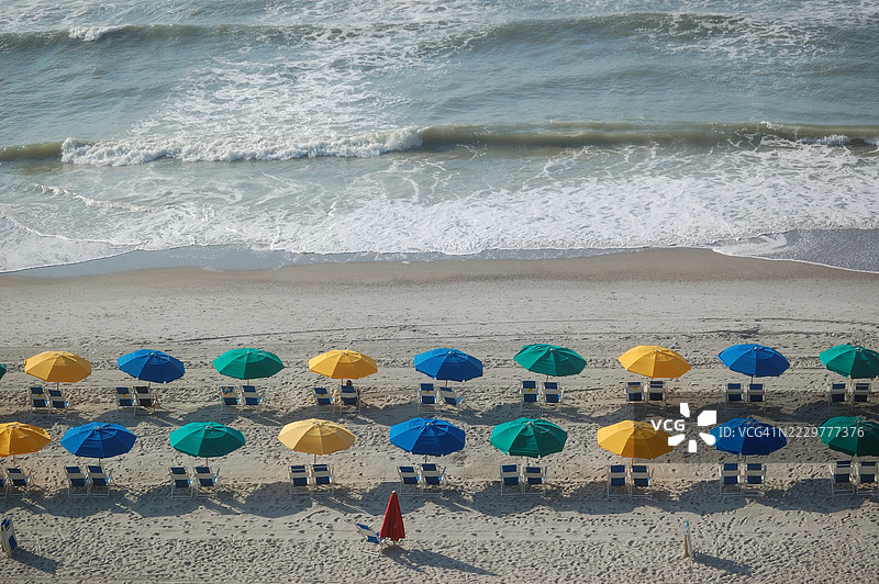 五彩缤纷的沙滩伞排成一排，位于美国南卡罗来纳州的默特尔海滩。图片素材