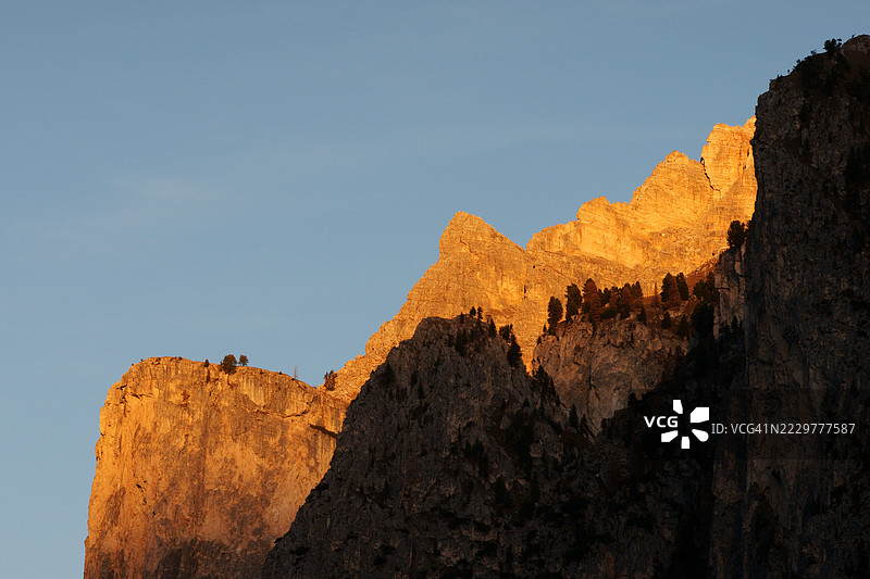 意大利瓦尔加尔德纳山谷的山峰在日落时分的金色阿尔卑斯光辉图片素材