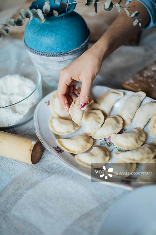 女人的手在土耳其乌萨克的桌子上准备自制饺子图片素材