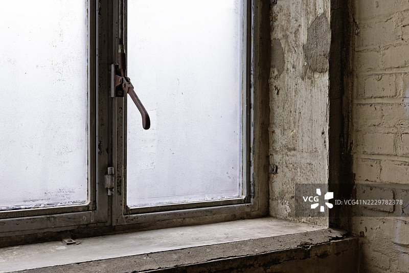 废弃建筑中的结霜窗户唤起神秘与衰败感图片素材