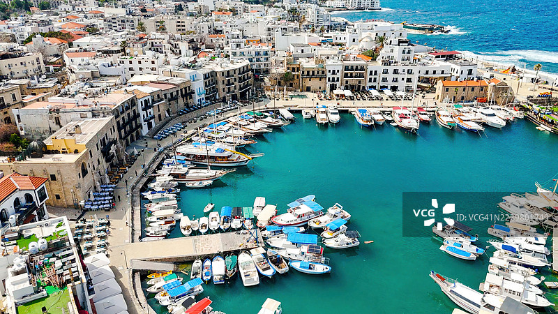 北塞浦路斯基尔尼亚港的鸟瞰图，展示了历史悠久的威尼斯建筑、碧蓝的地中海水域、游艇和基尔尼亚城堡，风景如画的海岸线和著名的旅游胜地。图片素材