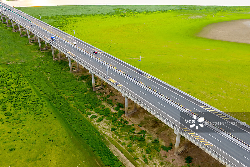 蜿蜒的道路穿过绿色草原图片素材