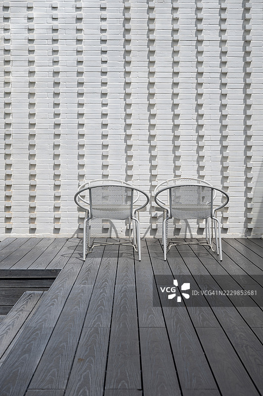 两把白色椅子放在木质甲板上图片素材