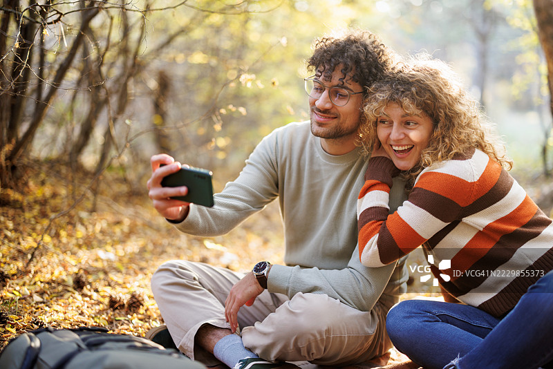 快乐的情侣在秋天的自然中自拍图片素材