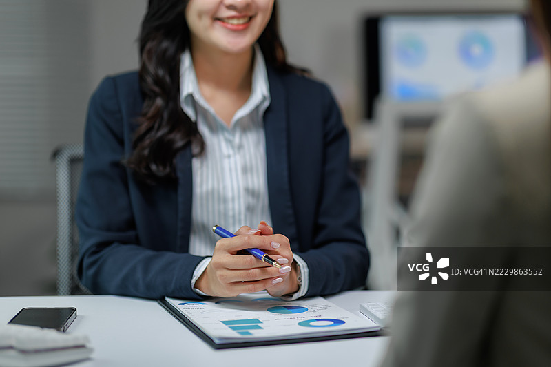 女商人在办公室会议中讨论财务图表和数据分析图片素材