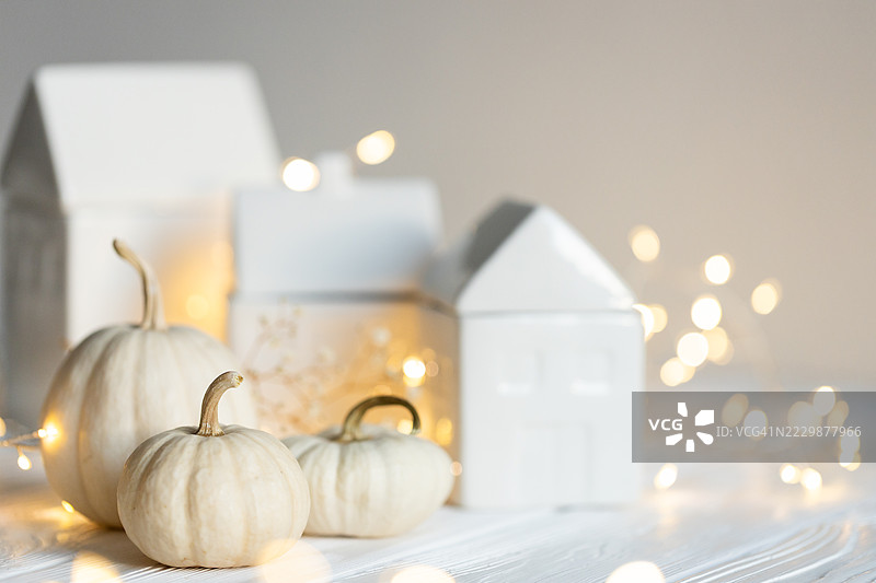 白色南瓜与陶瓷房屋和仙女灯图片素材