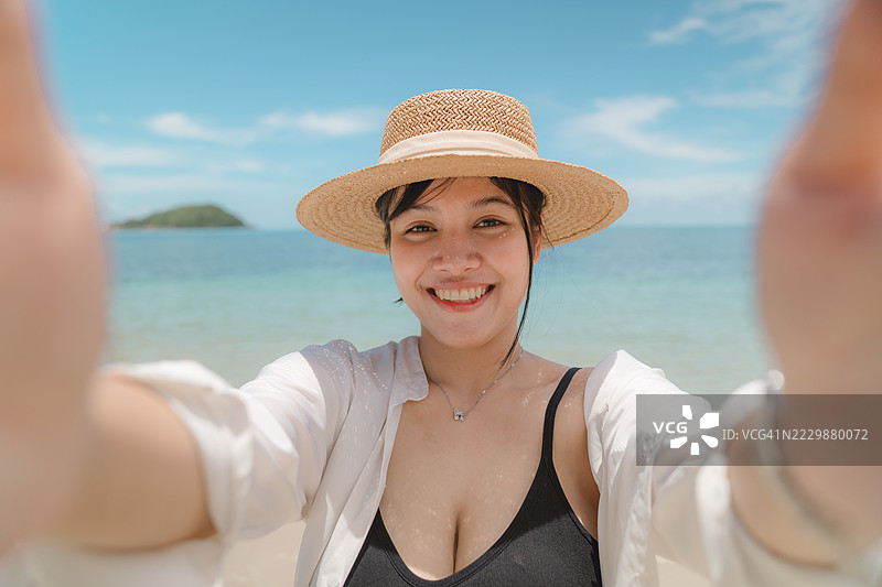 海滩上微笑的年轻女性肖像图片素材