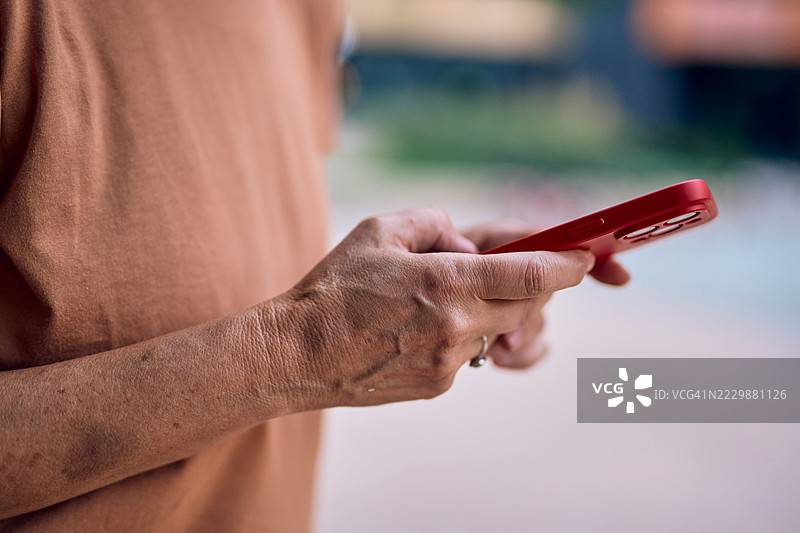 户外锻炼手指的老年女性使用智能手机图片素材