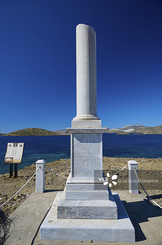 纪念碑，希波利特·比松，一座高耸的白色柱子在蓝天下矗立，俯瞰大海，位于希腊多德卡尼斯群岛阿斯提帕莱亚的阿纳利普西、马尔特扎纳。图片素材