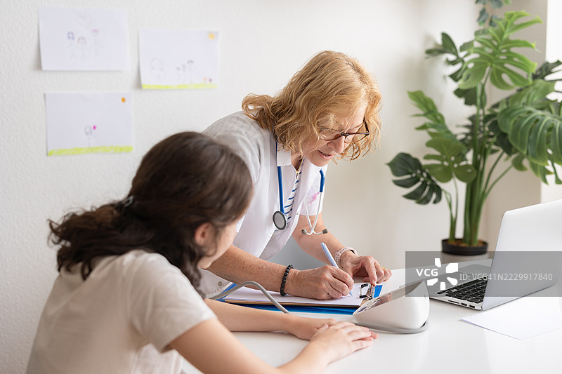 医生在为年轻患者测量血压时做笔记图片素材