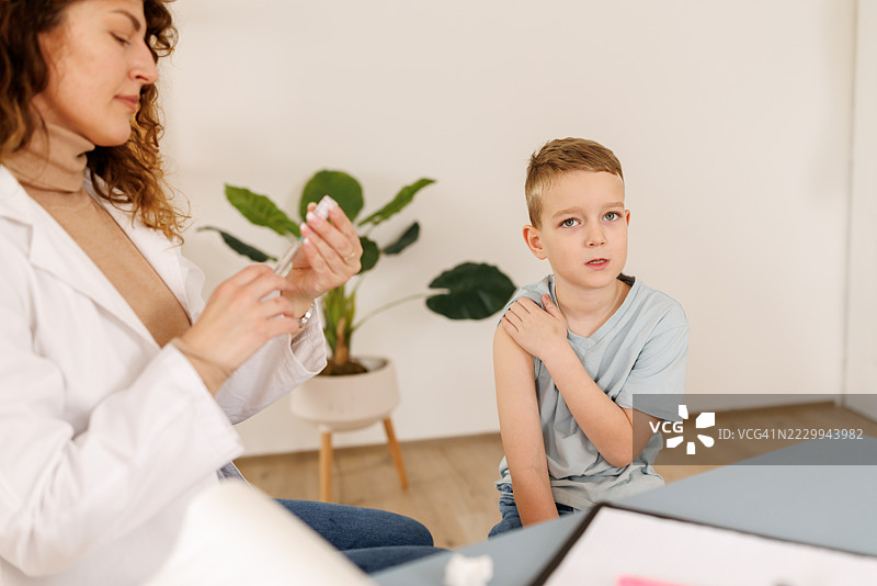 女医生在诊所给小男孩接种疫苗图片素材