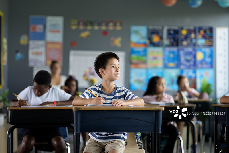 在展示教育海报的多元化课堂环境中，专注的学生们正在学习图片素材