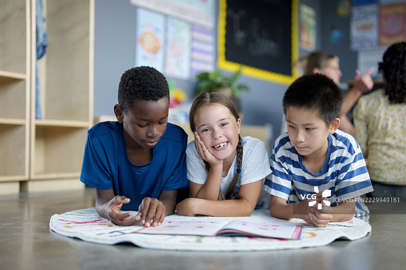 一群多元化的孩子在色彩缤纷的教室里合作完成学校作业图片素材