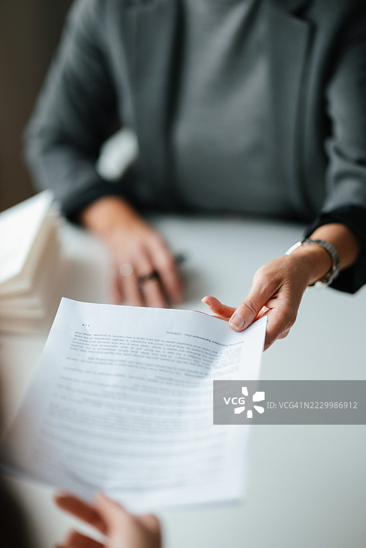 办公室环境中的专业会面，涉及文件转交图片素材