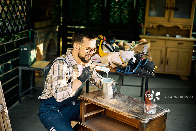 在家庭工作室环境中进行木工项目的男子图片素材