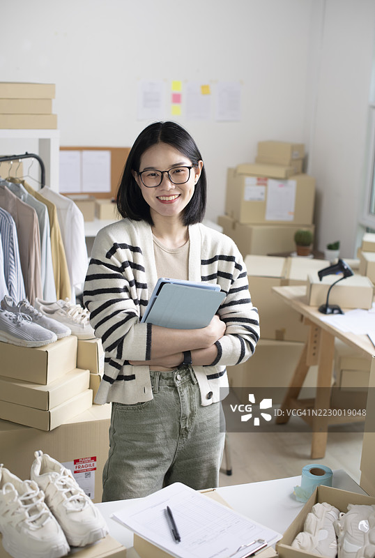 女性在线商店小企业主卖家企业家在桌子上打包邮寄包裹准备发货。电子商务代发货运输服务概念。图片素材