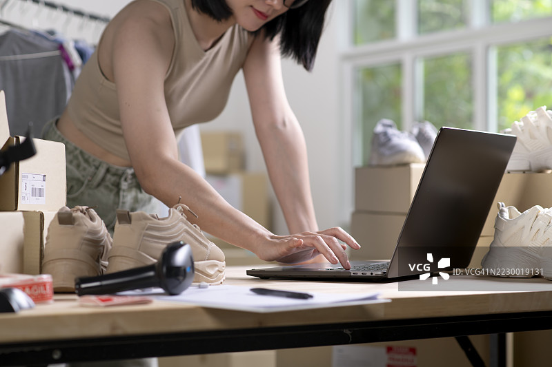 女性在线商店小企业主卖家企业家在桌子上打包邮寄包裹准备发货。电子商务代发货服务概念。图片素材