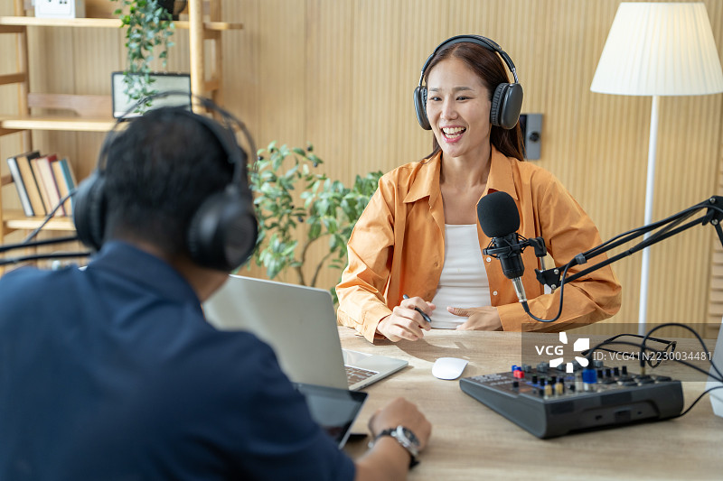 两位年轻的电台主持人在现代化的录音室录制播客图片素材