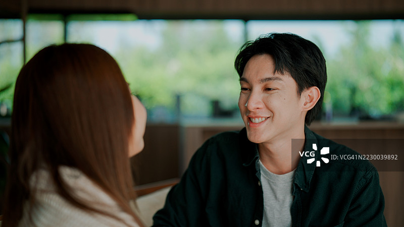 年轻的亚洲情侣在客厅的沙发上讨论他们的未来。图片素材