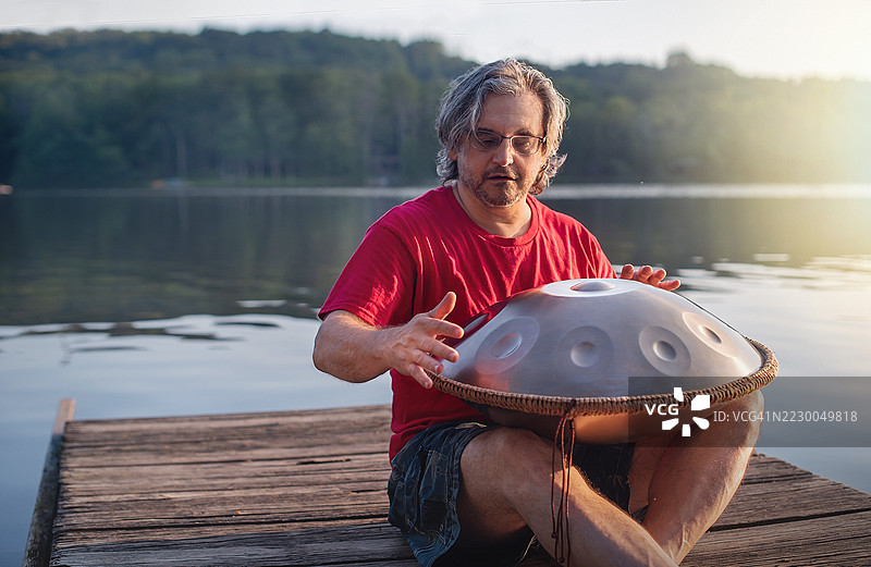 业余表演者在日落时分于波科诺湖畔演奏手碟鼓。图片素材