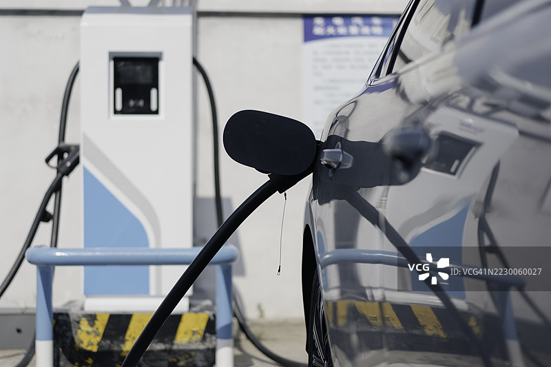 一辆电动汽车正在充电站充电图片素材