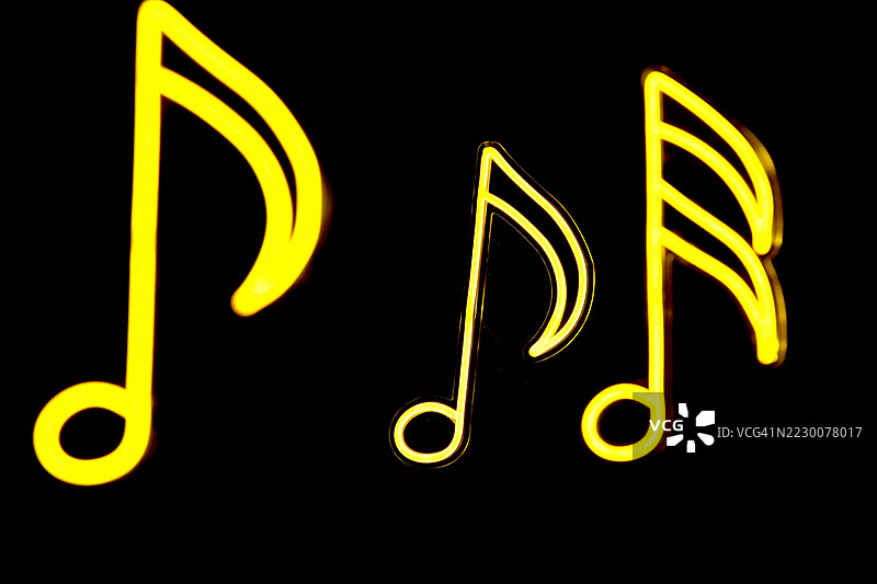 黑色背景上的发光霓虹音乐音符图片素材
