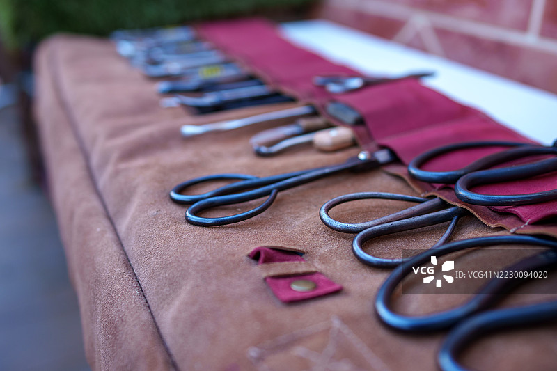 展示在皮革包上的盆栽修剪工具图片素材