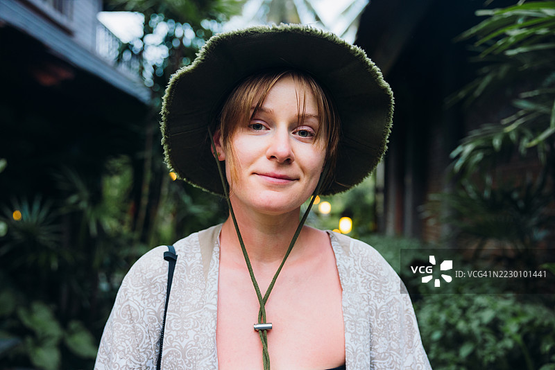 身着传统服饰的宁静女性在巴厘岛花园中漫步图片素材