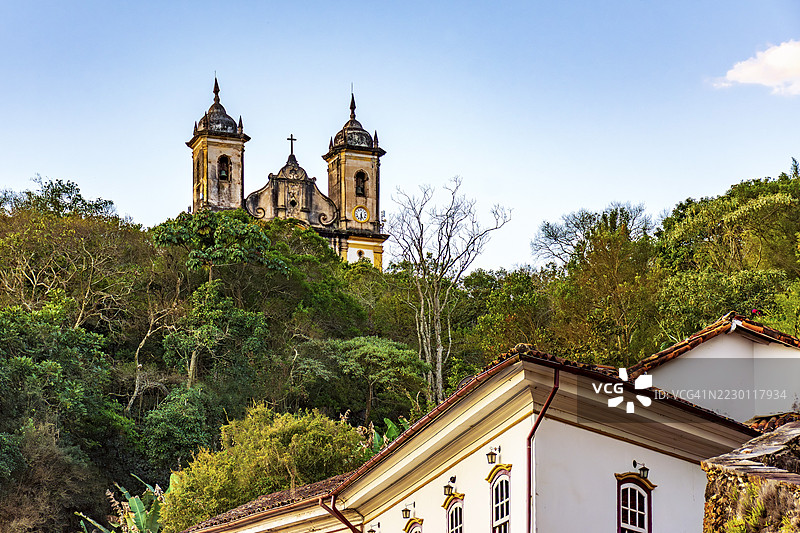巴西米纳斯吉拉斯州奥鲁普雷图市山丘间的历史建筑和巴洛克教堂被植被环绕图片素材