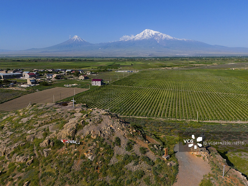 阿尔梅尼亚的广阔景观，背景是田野和山脉，清澈的天空下有一个小村庄，鸟瞰图，包含土耳其的阿拉拉特山和小阿拉拉特山，位于阿拉拉特省。图片素材