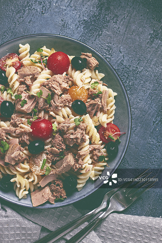 意大利螺旋面沙拉，配有罐装金枪鱼、樱桃番茄和橄榄、帕尔马干酪、微型绿叶菜，自制，无人。图片素材