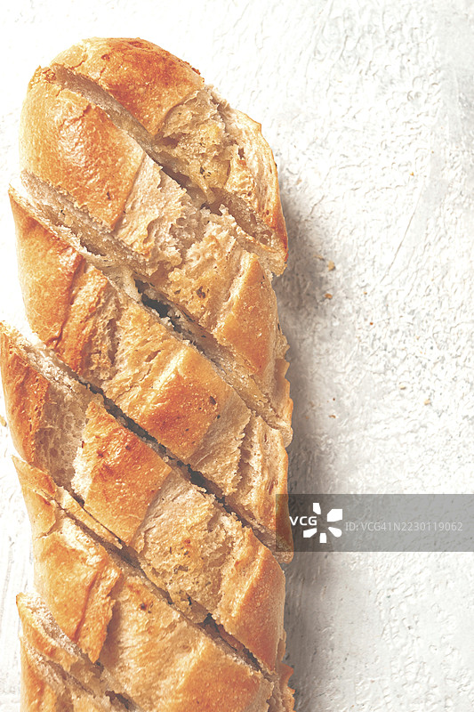 大蒜面包，涂有大蒜黄油和香草的法棍，放在浅色桌子上，俯视图图片素材