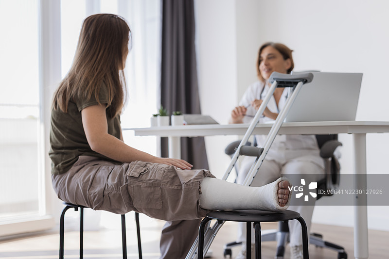 腿部骨折的少女正在接受医生的医疗建议图片素材