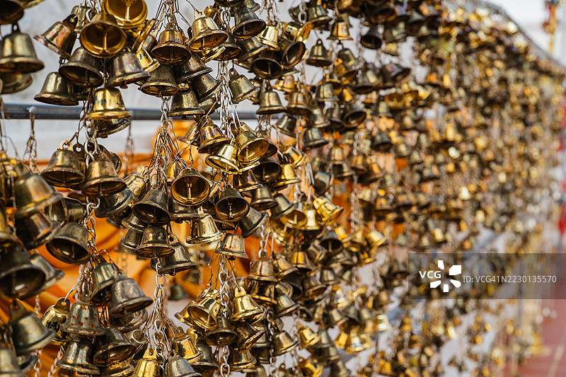在泰国寺庙中，数十个小金铃铛成串悬挂，象征着祈祷、祝福和精神供奉。图片素材