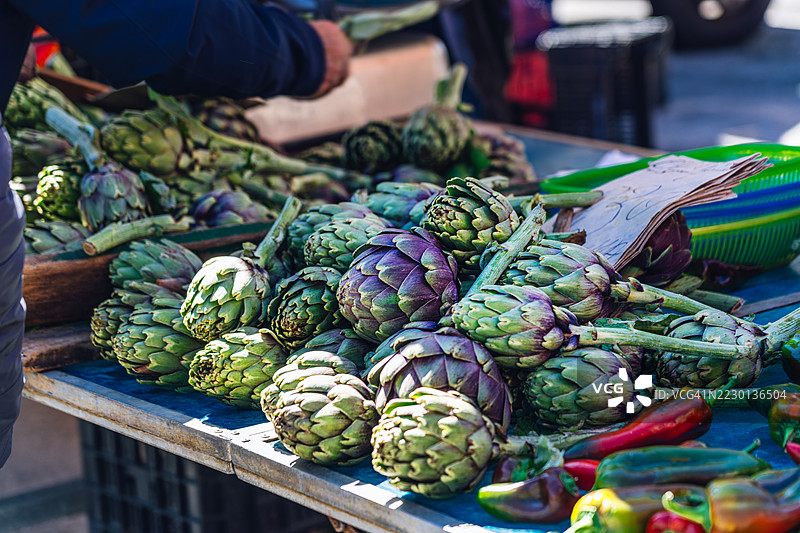 阳光明媚的农贸市场上展示的新鲜朝鲜蓟图片素材