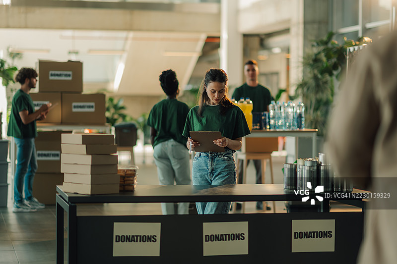 志愿者在慈善捐赠中心整理捐款图片素材